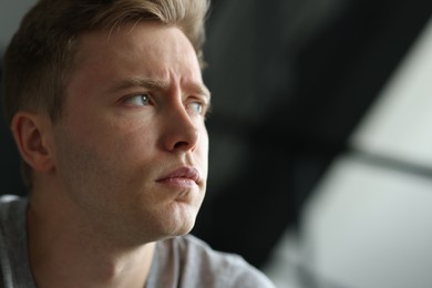 Photo of Sad man on blurred background, space for text. Depression