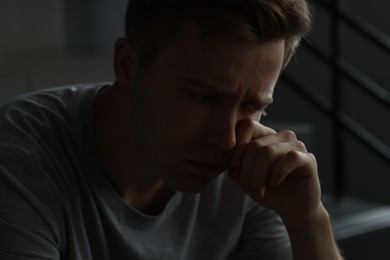 Photo of Sad man crying alone in darkness. Depression
