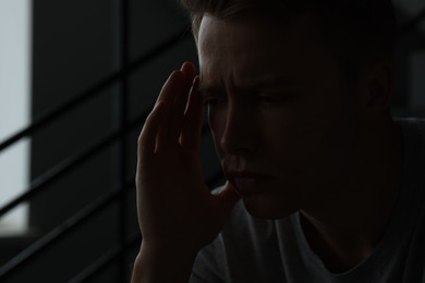 Photo of Sad tired man alone in darkness. Depression
