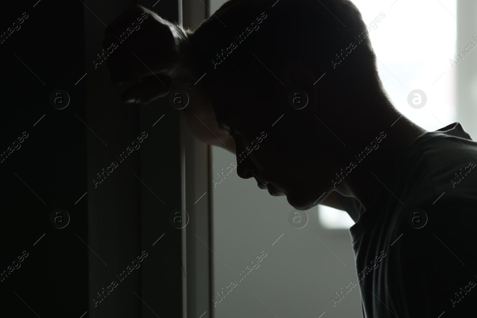 Sadness and depression. Silhouette of man in darkness against daylight Photo of Sadness and depression. Silhouette of man in darkness against daylight