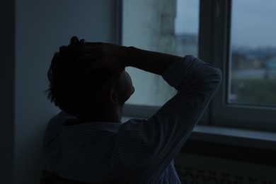 Photo of Sad tired man in darkness at home. Depression