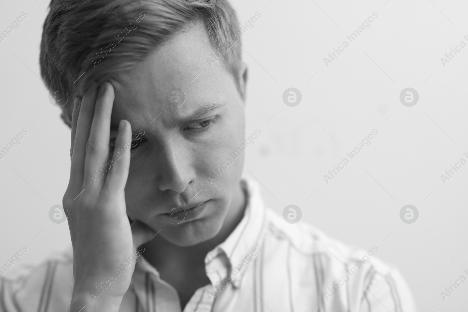 Sad tired man on grey background. Black and white effect Photo of Sad tired man on grey background. Black and white effect