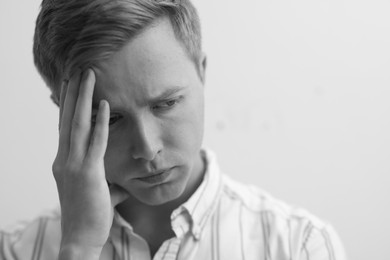 Photo of Sad tired man on grey background. Black and white effect
