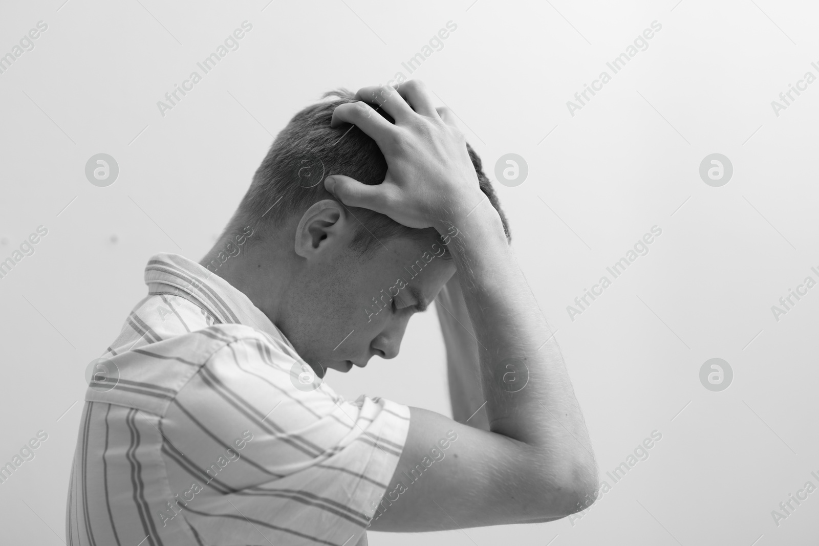Sad tired man on grey background. Black and white effect Photo of Sad tired man on grey background. Black and white effect