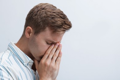 Photo of Sad tired man on light background. Space for text