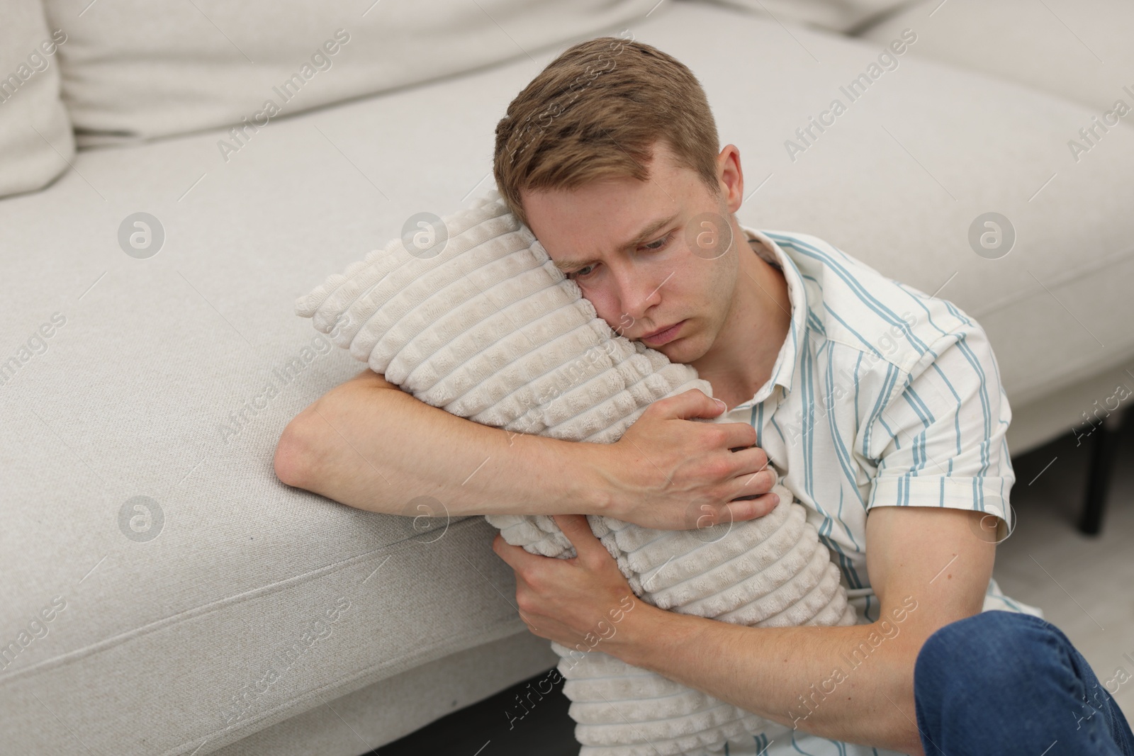 Sad tired man hugging pillow at home Photo of Sad tired man hugging pillow at home