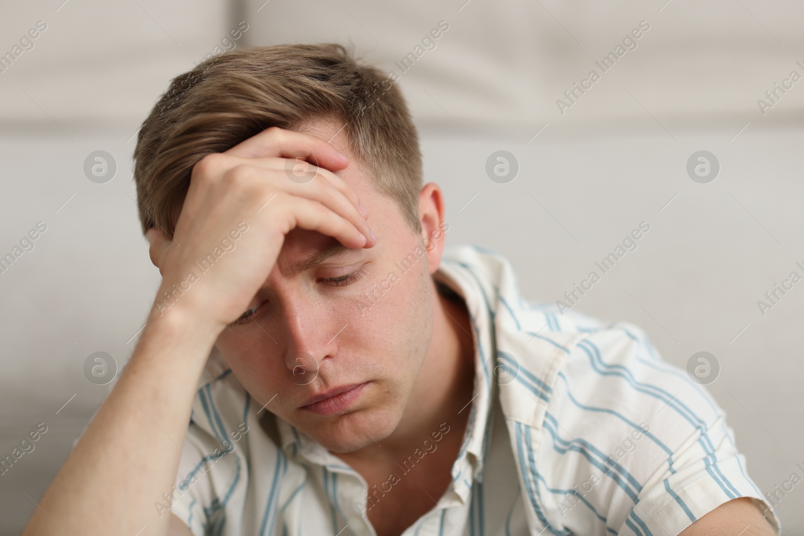 Sad thoughtful man on blurred light background Photo of Sad thoughtful man on blurred light background