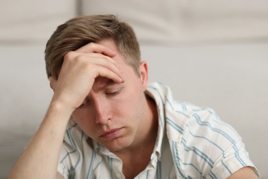 Photo of Sad thoughtful man on blurred light background