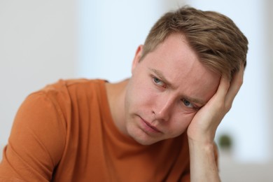 Photo of Portrait of sad thoughtful man on blurred background