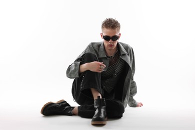 Photo of Handsome young man wearing stylish jacket and sunglasses on white background