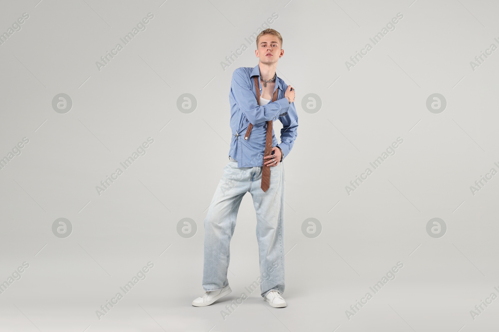 Photo of Handsome young man wearing stylish clothes on light grey background