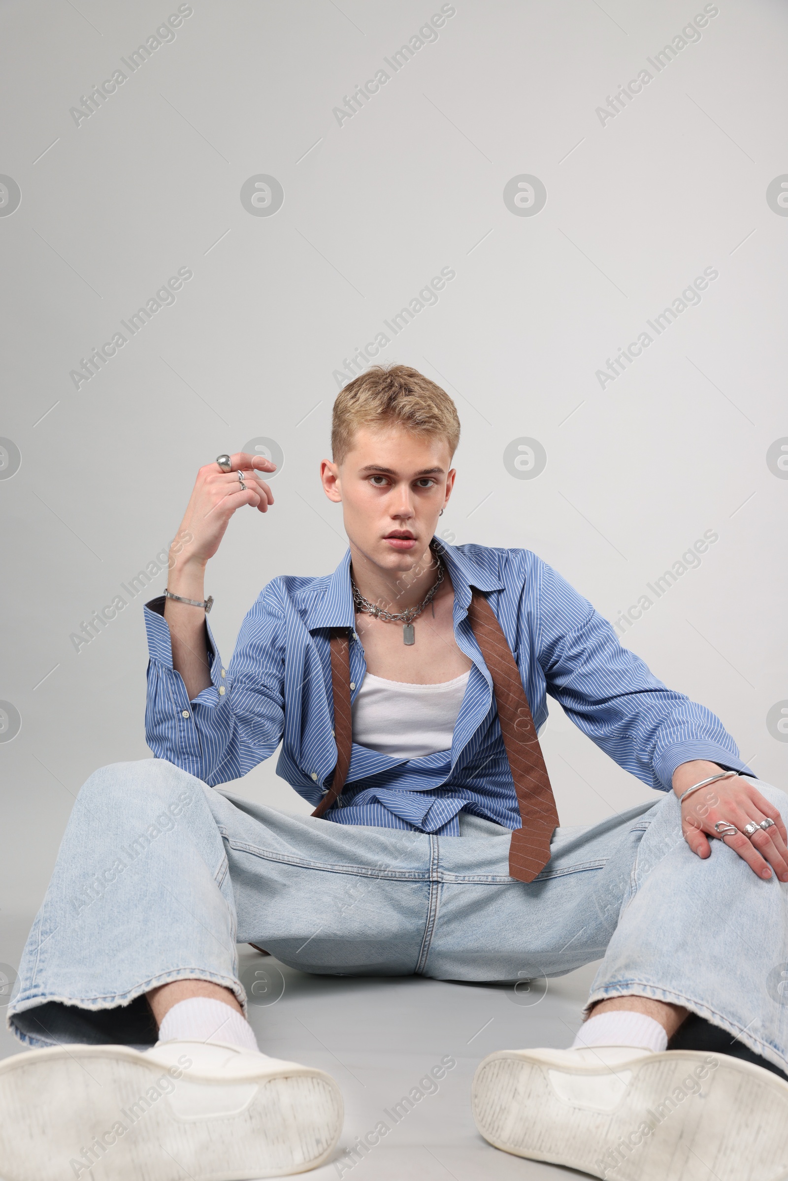 Photo of Handsome young man wearing stylish clothes on light grey background