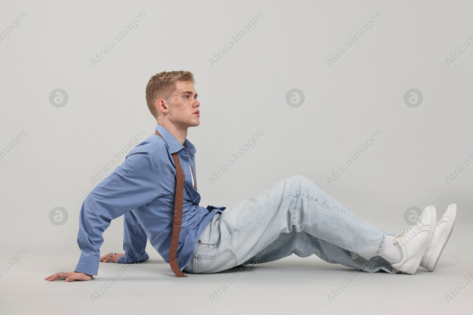Photo of Handsome young man wearing stylish clothes on light grey background