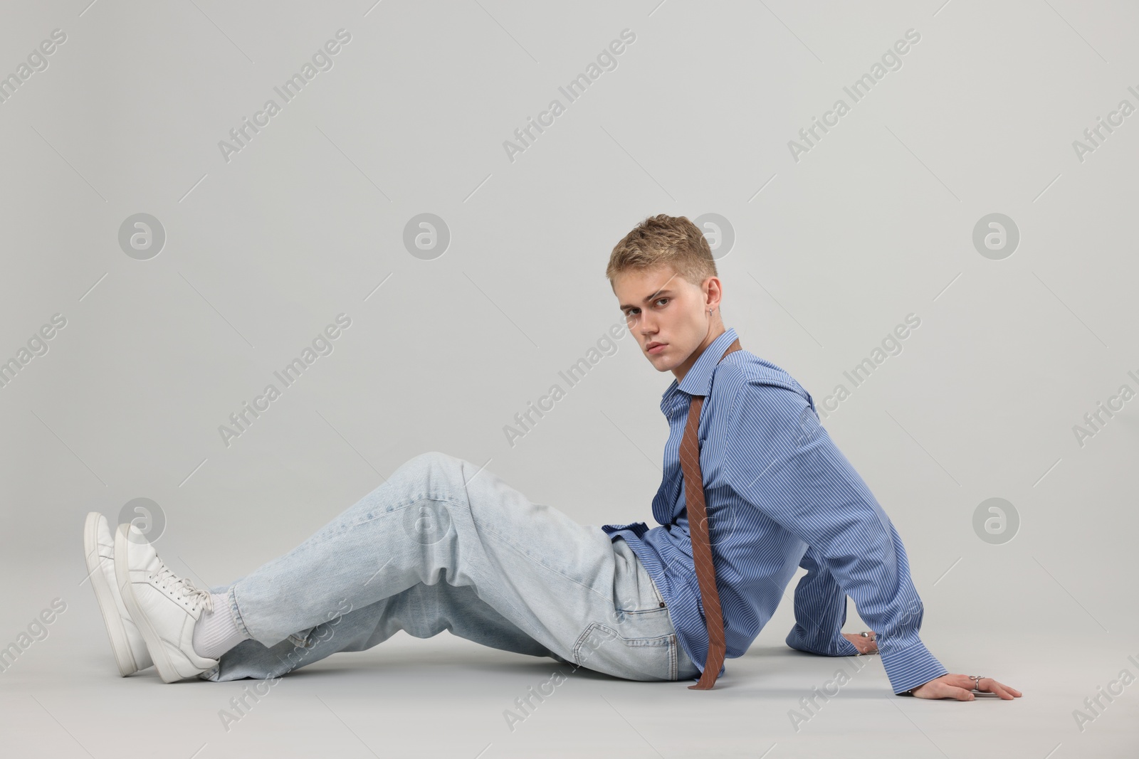 Photo of Handsome young man wearing stylish clothes on light grey background