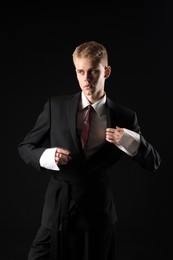 Photo of Handsome young man wearing stylish suit on black background