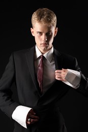 Photo of Handsome young man wearing stylish suit on black background