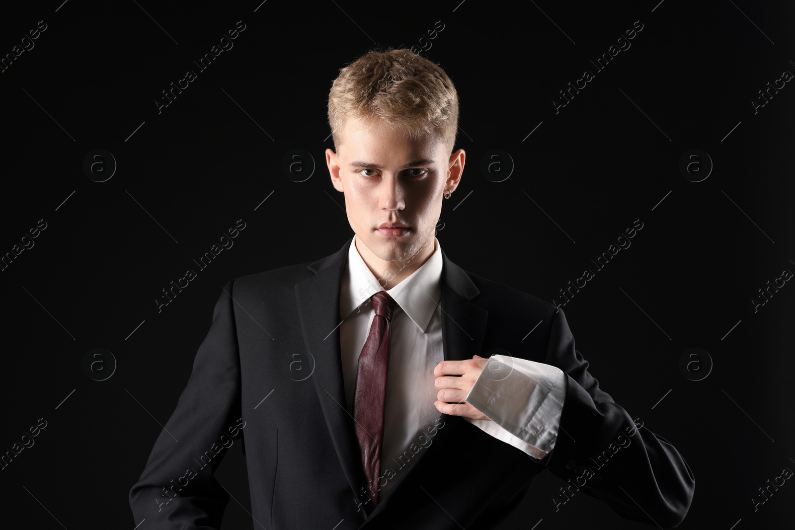 Photo of Handsome young man wearing stylish suit on black background
