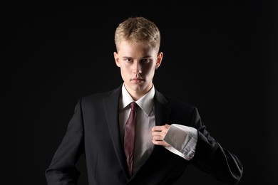 Photo of Handsome young man wearing stylish suit on black background