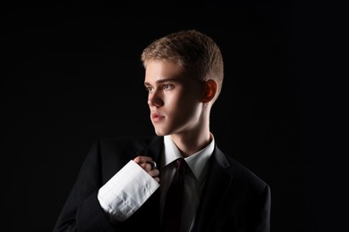Photo of Handsome young man wearing stylish suit on black background
