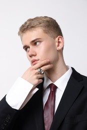 Photo of Handsome young man wearing stylish suit and ring on white background