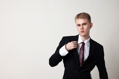 Photo of Handsome young man wearing stylish suit on white background, space for text