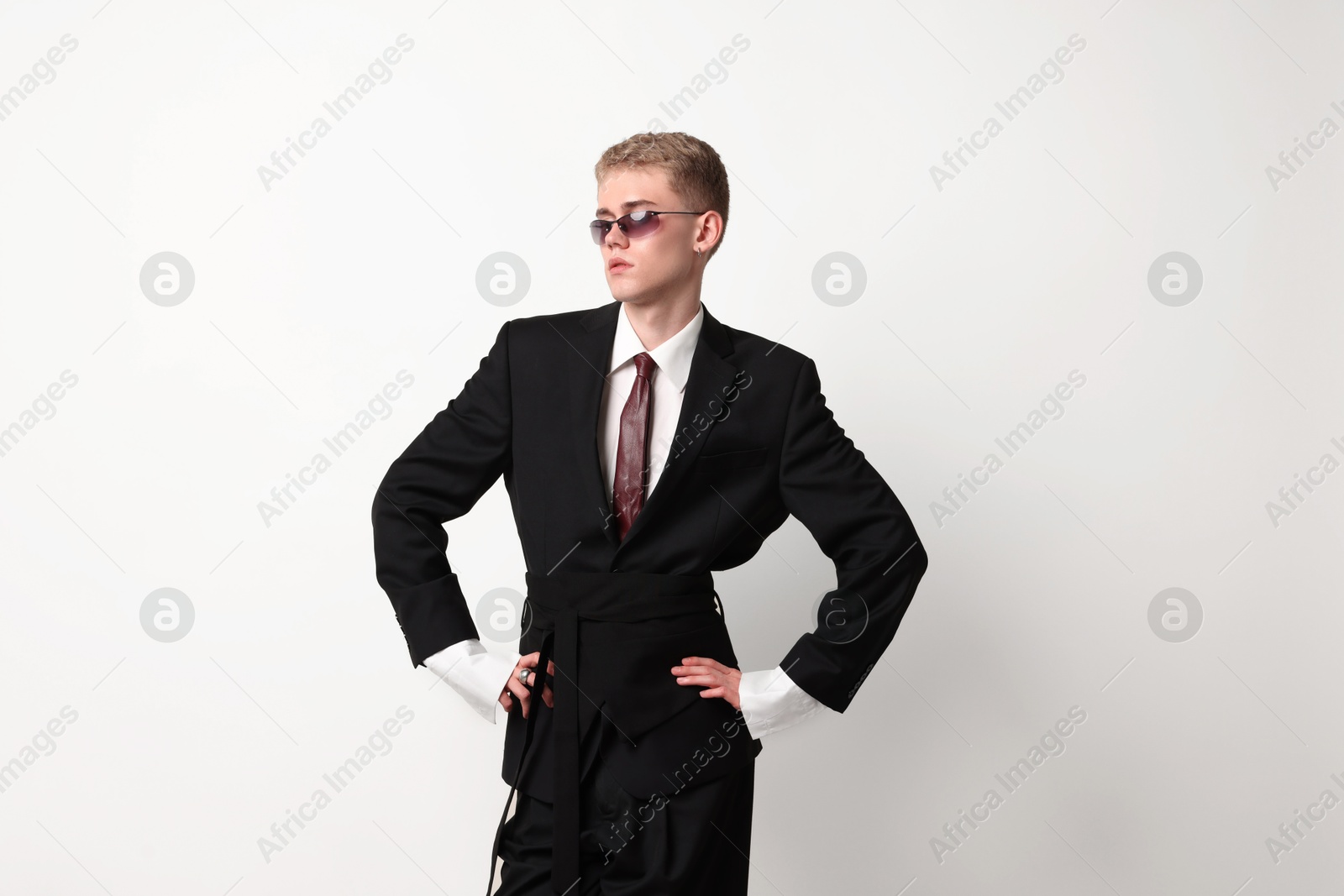 Photo of Handsome young man wearing stylish suit and sunglasses on white background