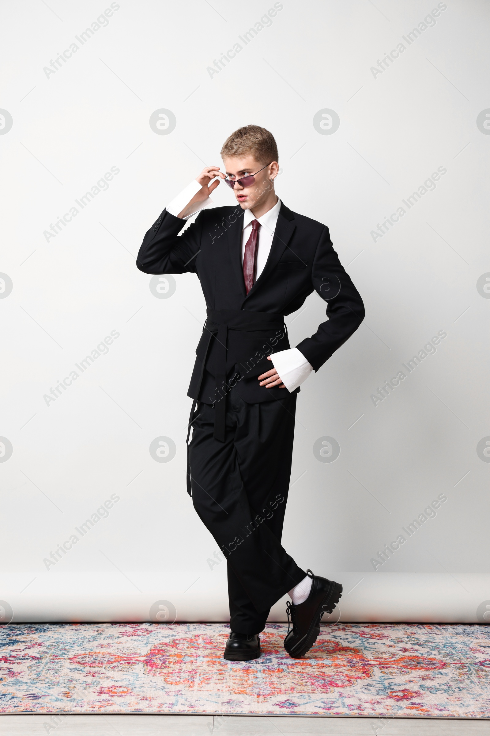 Photo of Handsome young man wearing stylish suit and sunglasses on white background