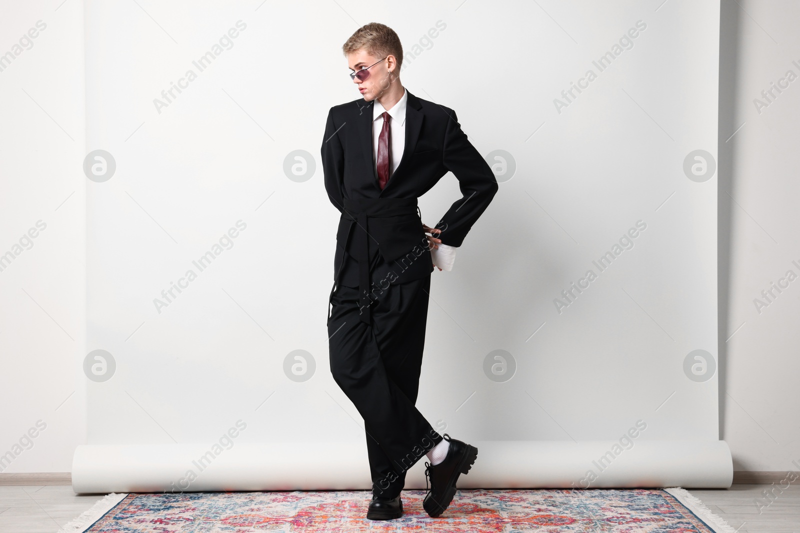 Photo of Handsome young man wearing stylish suit and sunglasses on white background