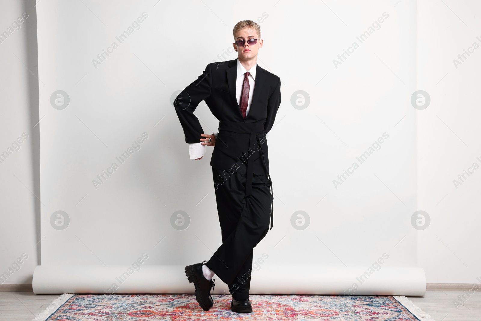 Photo of Handsome young man wearing stylish suit and sunglasses on white background