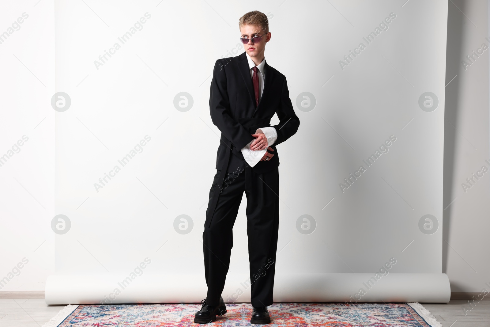 Photo of Handsome young man wearing stylish suit and sunglasses on white background
