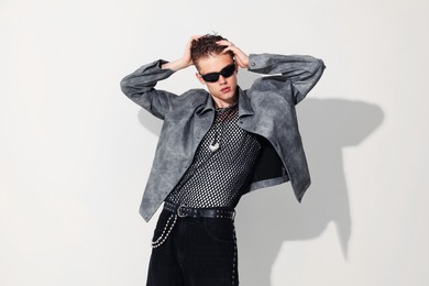 Photo of Handsome young man wearing stylish jacket and sunglasses on white background