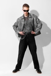 Photo of Handsome young man wearing stylish jacket and sunglasses on white background