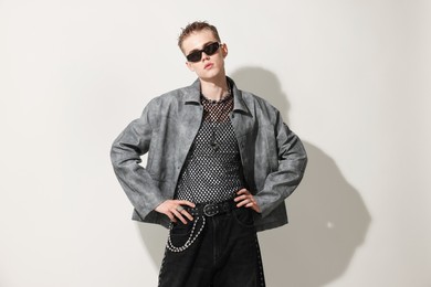 Photo of Handsome young man wearing stylish jacket and sunglasses on white background