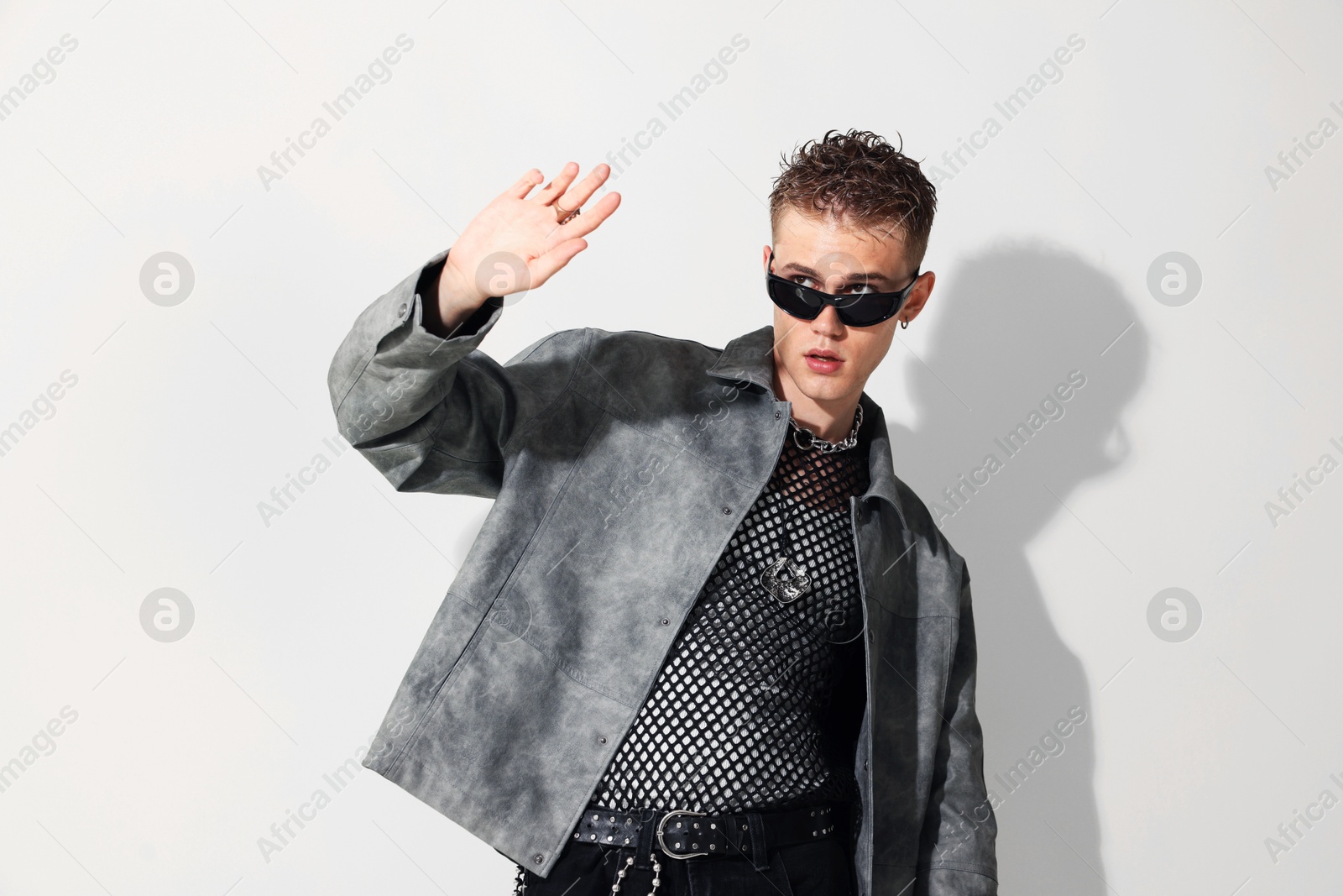 Photo of Handsome young man wearing stylish jacket and sunglasses on white background