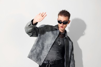 Photo of Handsome young man wearing stylish jacket and sunglasses on white background