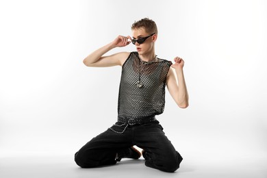 Photo of Handsome young man wearing sunglasses on white background