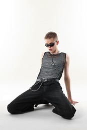 Photo of Handsome young man wearing sunglasses on white background