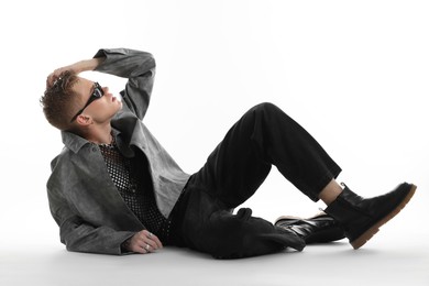 Photo of Handsome young man wearing stylish jacket and sunglasses on white background