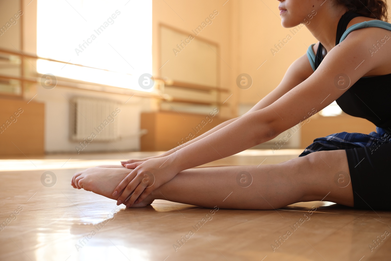Teenage girl stretching on floor in dance class, closeup Photo of Teenage girl stretching on floor in dance class, closeup