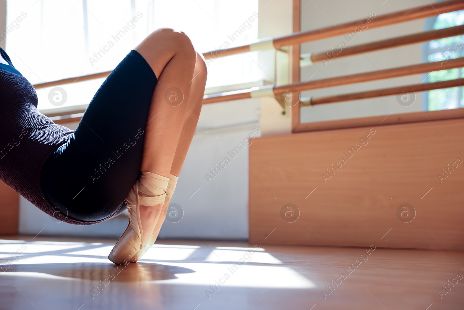 Photo of Teenage girl in pointe shoes training indoors, closeup. Space for text
