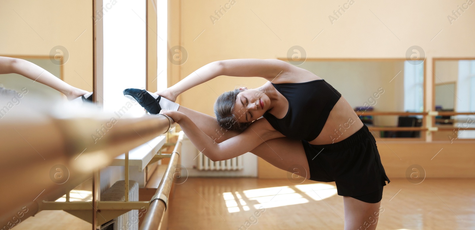Beautiful teenage girl stretching in barre studio Photo of Beautiful teenage girl stretching in barre studio