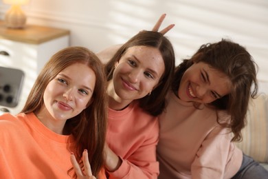 Photo of Portrait of happy friends taking selfie at home