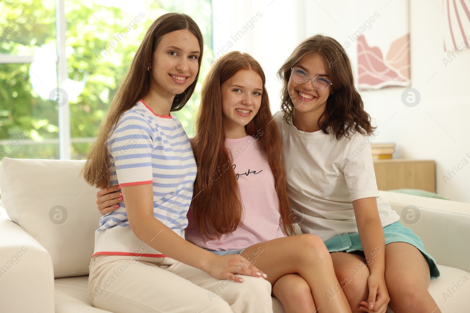 Portrait of happy friends on sofa at home Photo of Portrait of happy friends on sofa at home