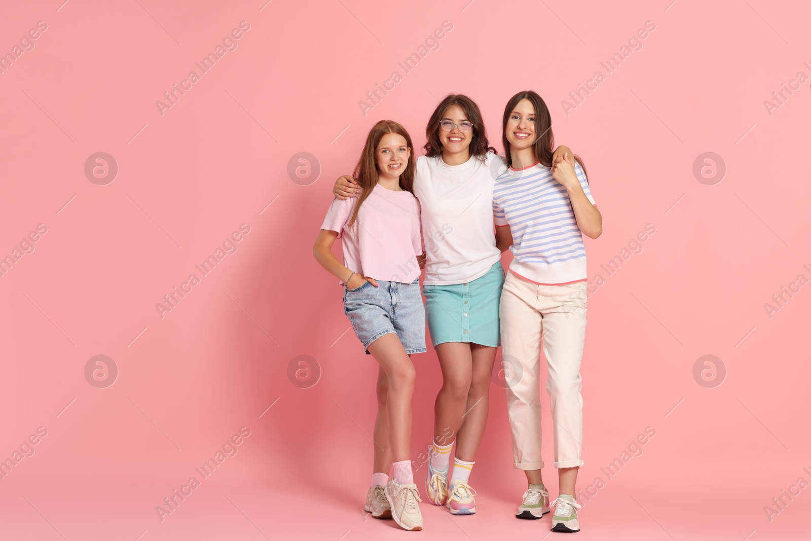 Portrait of happy friends on pink background, space for text Photo of Portrait of happy friends on pink background, space for text