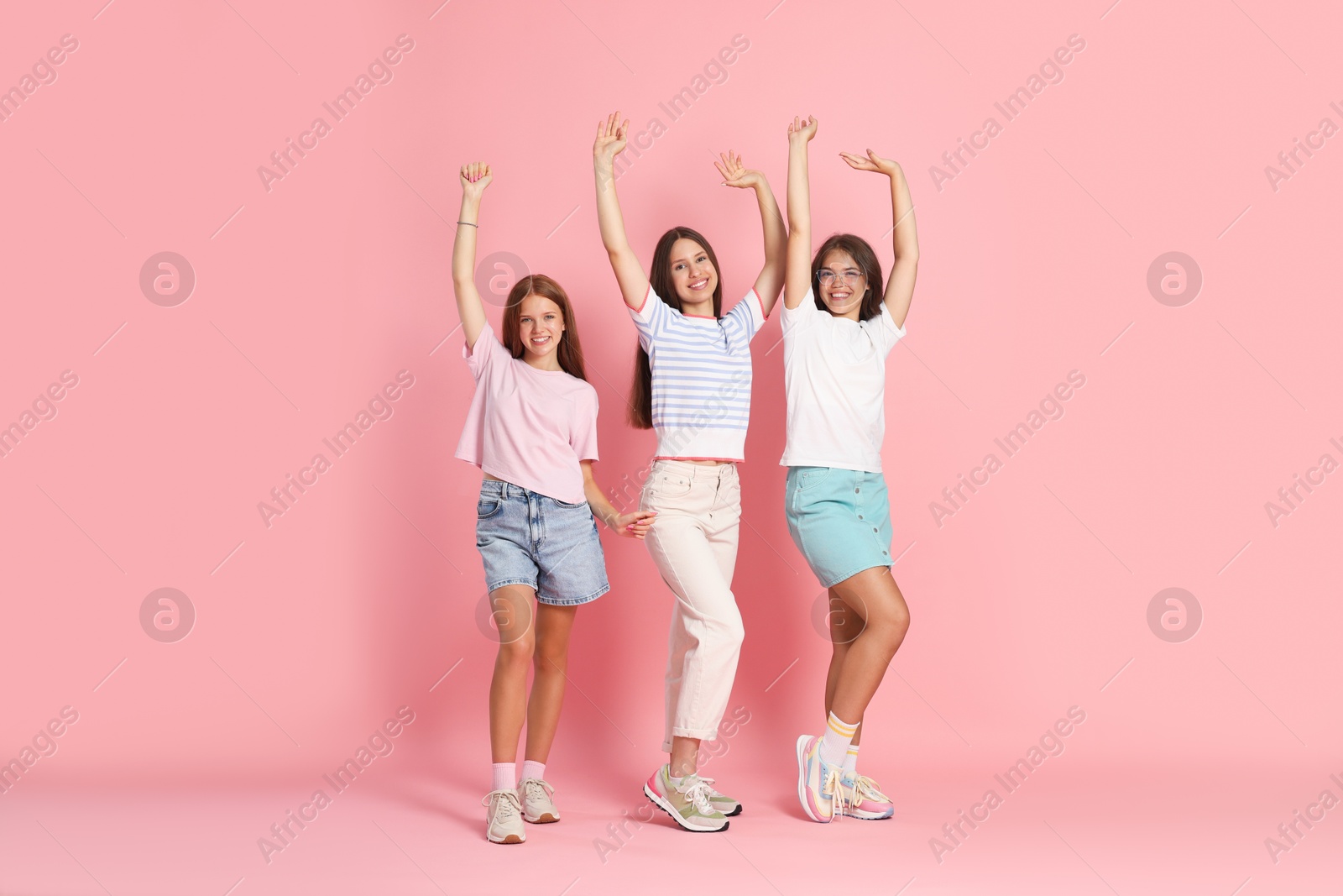 Photo of Portrait of happy friends on pink background