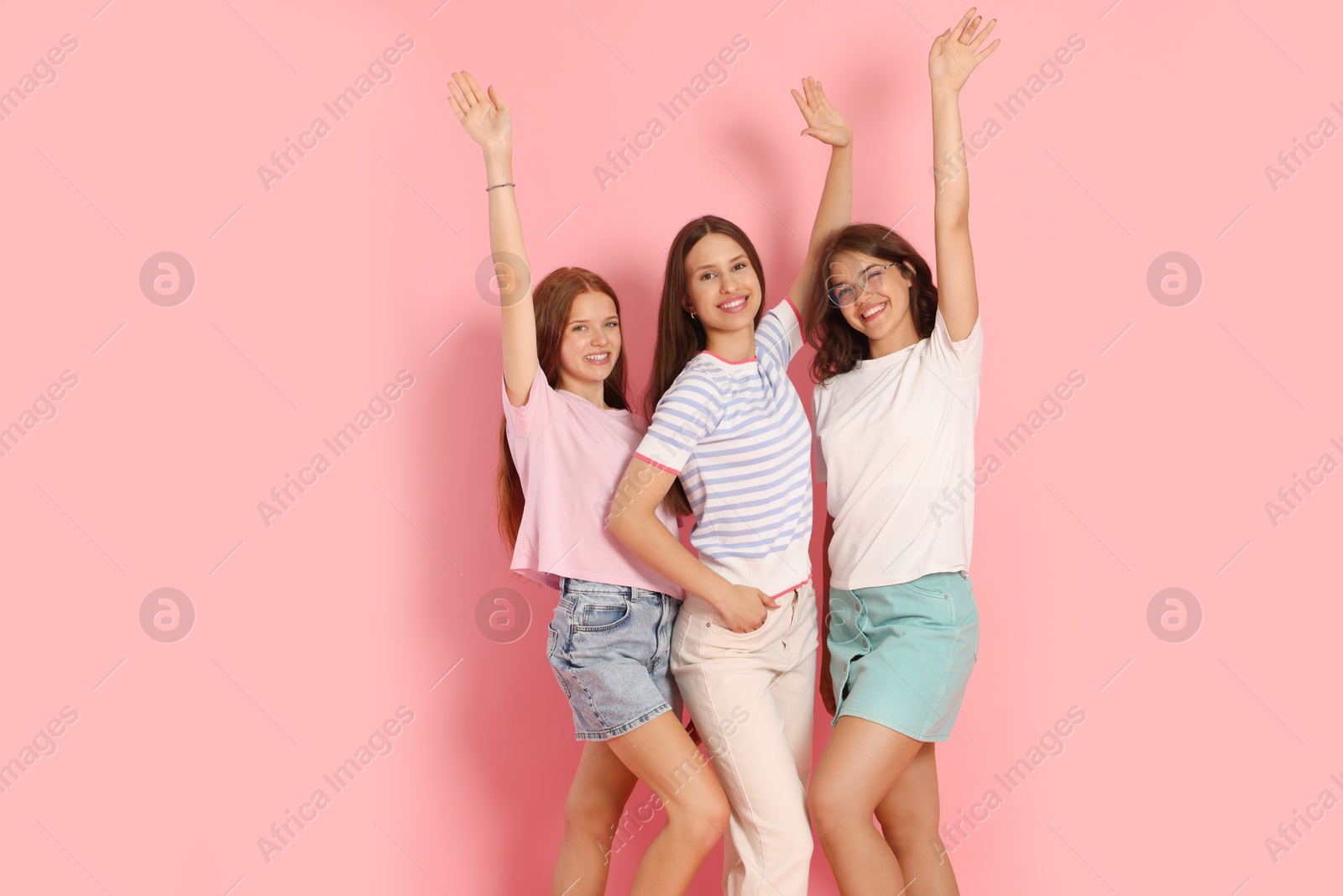 Portrait of happy friends on pink background, space for text Photo of Portrait of happy friends on pink background, space for text