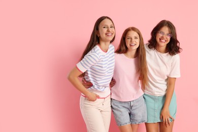 Photo of Portrait of happy friends on pink background, space for text