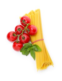 Photo of Raw spaghetti pasta, tomatoes and basil isolated on white, top view