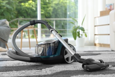Photo of One vacuum cleaner on floor indoors. Household appliance