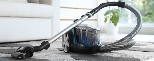Photo of One vacuum cleaner on floor indoors. Household appliance